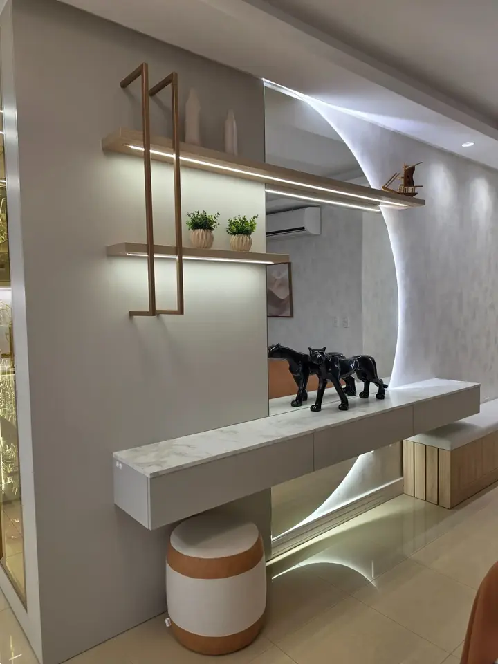 Hall planejado com espelho, prateleiras iluminadas e estrutura metálica dourada