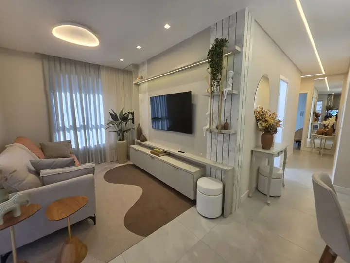 Living integrado com painel de televisão, marcenaria clara e iluminação linear